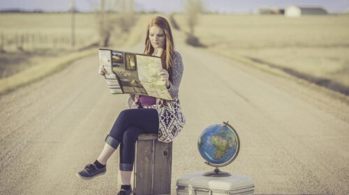10 Big Travel Trends That Will Fade with Generation X - girl with globe and map What to Expect From a Nationwide Auto Transport Service