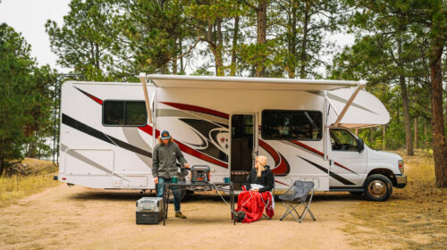 Looking for a Unique Weekend Break Idea? Here’s Why You Should Consider an RV Trip - Man and Woman Relaxing in Front of RV