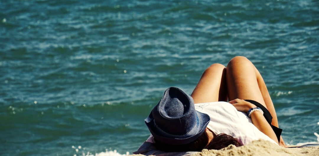 Luxury Beach Vacations: How To Avoid Just Lounging Around All Day! - Woman Lounging on a 4 Easy Beach Frizz Solutions for Humid Beach Days