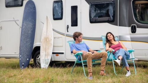 How to Choose the Right RV Park For Your Next Getaway - Couple Relaxing in Front of RV Going on an RV Trip for the First Time? Here's What you Need to Know How to Choose an RV Park For Long-Term Stays