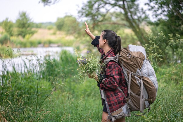 Spice Up Your Daily Routine With 6 Simple Lifestyle Tweaks - Woman Hiking and Picking Flowers