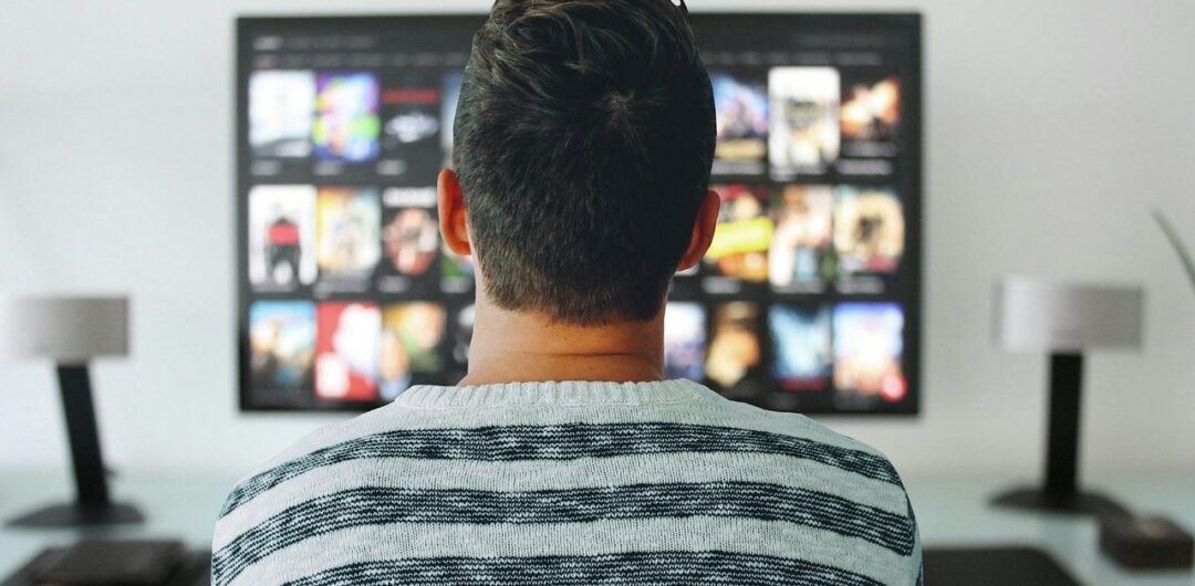 How Digital Entertainment Is Reshaping the Modern Staycation Experience - Man in Front of TV